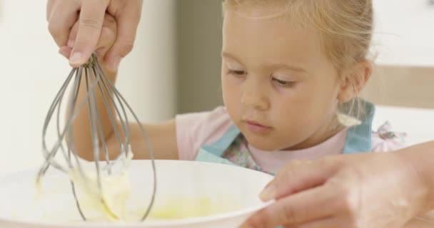 Fascinován holčička, naučit se péct — Stock video