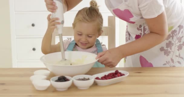 Cute little girl learning to bake from mother — Stock Video