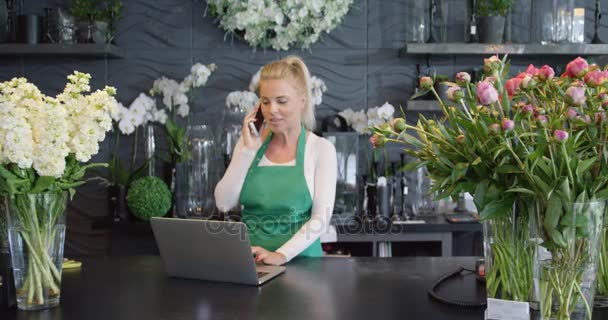 Teléfono de mujer hablando en floristería — Vídeo de stock