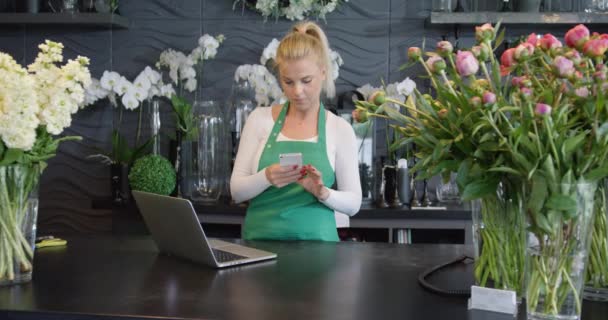 Frau mit Handy im Geschäft — Stockvideo