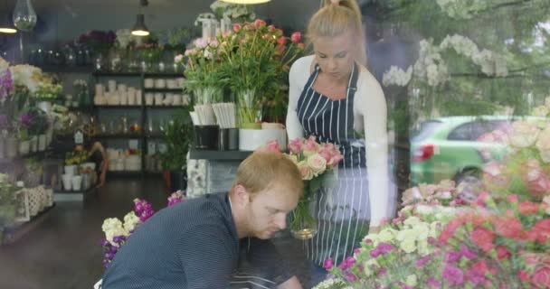 Man och kvinna i blommig butik arbetar — Stockvideo