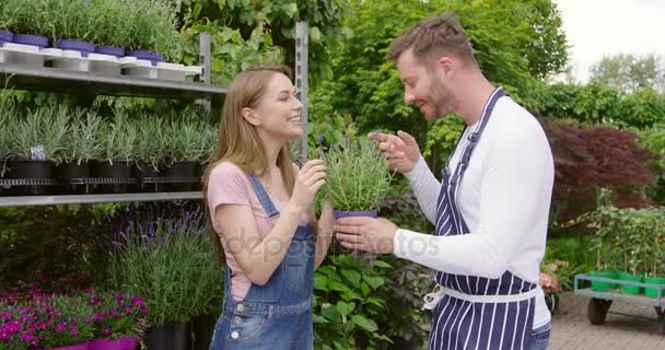 Frau schnüffelt an Topfblume — Stockvideo