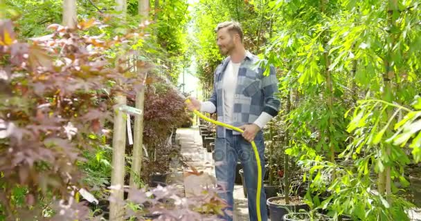 El hombre regando las plantas en el jardín — Vídeo de stock