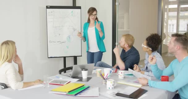 Mulher mostrando gráficos para colegas de trabalho — Vídeo de Stock