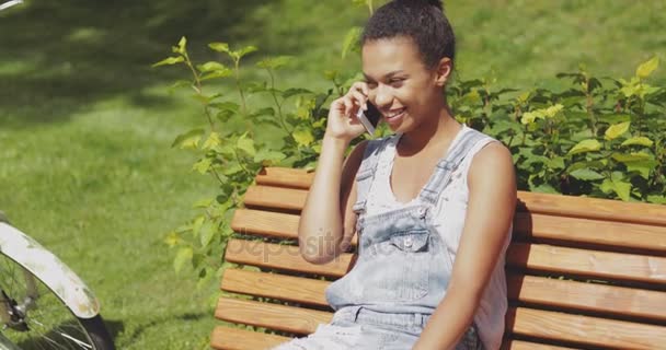 Cheerful woman talking smartphone in park — Stock Video