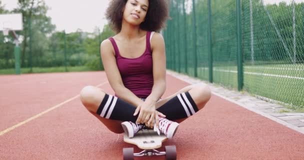 Charming model sitting on skateboard — Stock Video