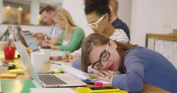 Empleado durmiendo en la mesa con compañeros de trabajo — Vídeos de Stock