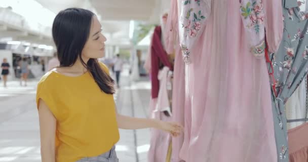 Chica explorando ropa en el centro comercial — Vídeos de Stock