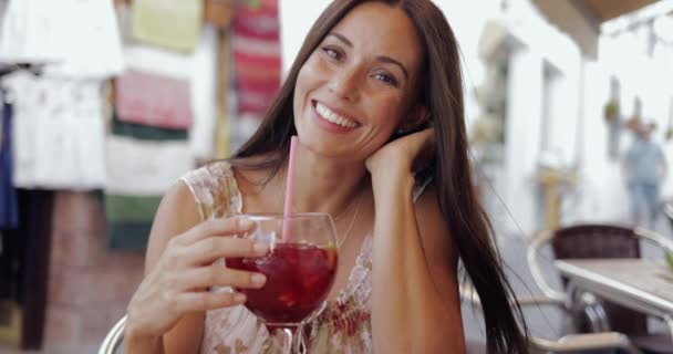 Femme souriante posant avec boisson dans un café — Video