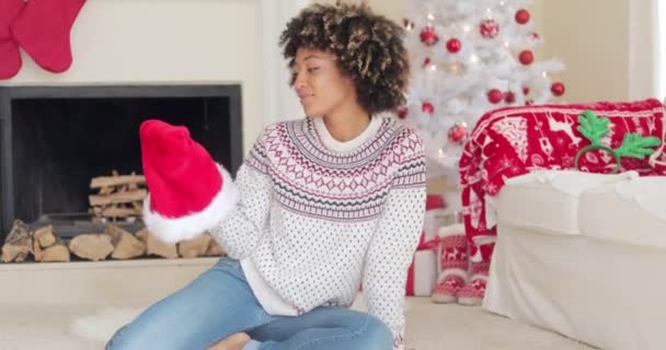 Sorrindo jovem segurando um chapéu de Papai Noel — Vídeo de Stock