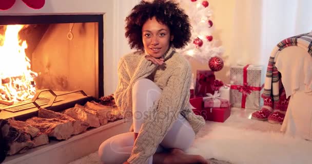 Woman seated by fireplace and holiday setting — Stock Video