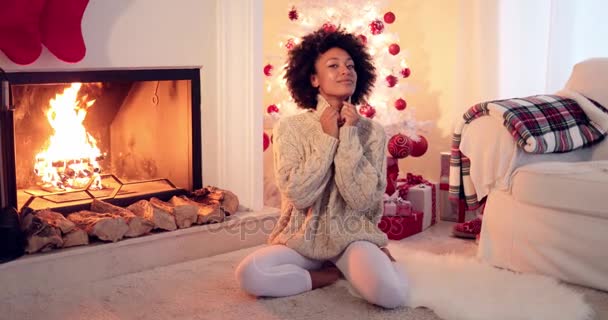 Frau sitzt neben weißem Weihnachtsbaum und Geschenken — Stockvideo