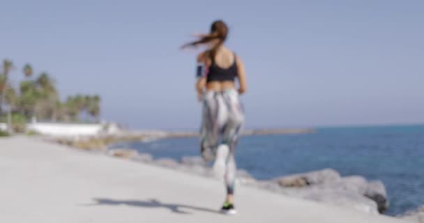 Chica anónima corriendo en el paseo marítimo — Vídeo de stock