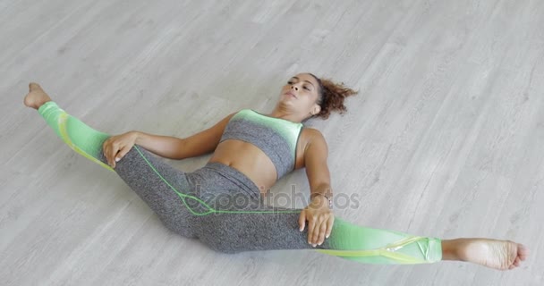 Donna sdraiata e gambe stretching — Video Stock