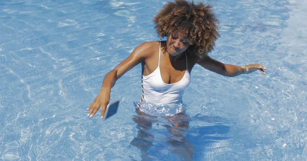 Mulher deixando cair o telefone na piscina — Fotografia de Stock