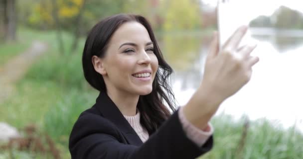 Kvinnan tar selfie nära pond — Stockvideo