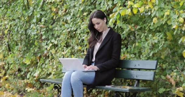 使用笔记本电脑在公园里的漂亮女人 — 图库视频影像