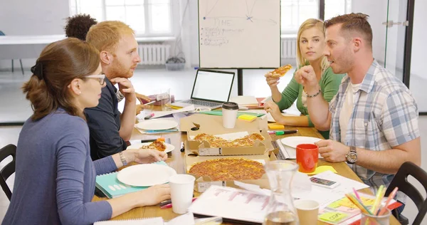Les jeunes profitent de la pizza au bureau — Photo