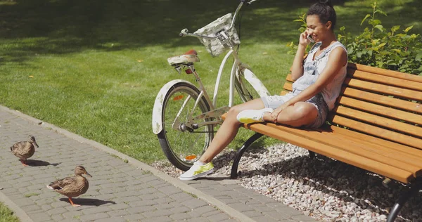 Kvinnan pratar telefon på bänk — Stockfoto