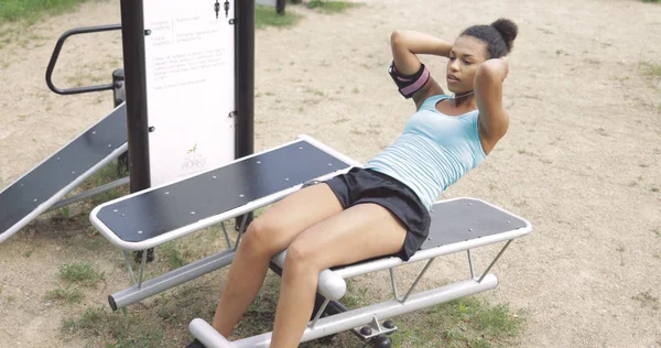 Chica entrenando abdominales en el parque — Foto de Stock