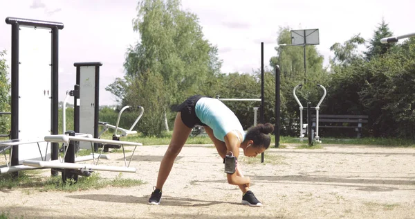 Ragazza che si estende sul terreno sportivo — Foto Stock