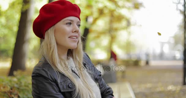 Vrouw in rode baret ontspannen op de Bank — Stockvideo
