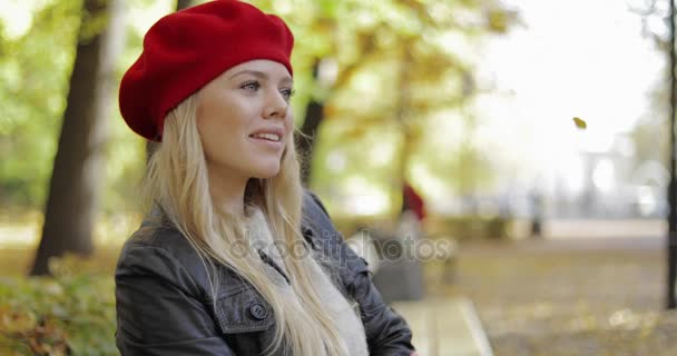 Mujer en boina roja relajándose en el banco — Vídeos de Stock