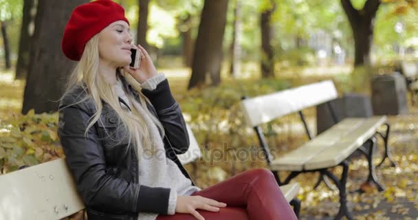 Nő a red svájcisapka beszél a telefonon — Stock videók