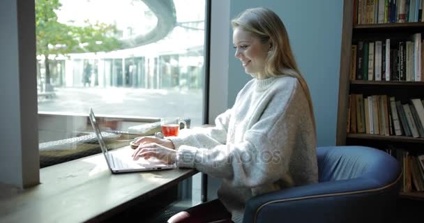 Mujer en sillón cómodo usando portátil — Vídeo de stock