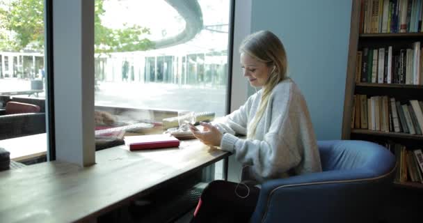 Mujer usando teléfono inteligente en la ventana delantera — Vídeos de Stock