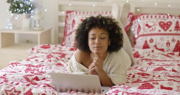 Schöne Frau liest etwas auf Laptop im Bett — Stockvideo