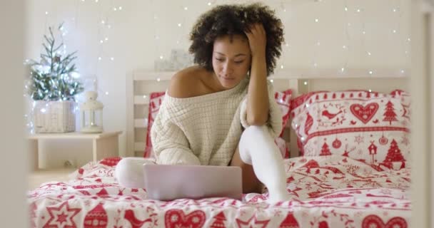 Mujer en suéter en la cama con ordenador portátil — Vídeo de stock
