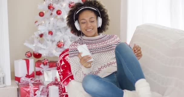 Chica joven relajante escuchando música navideña — Vídeos de Stock