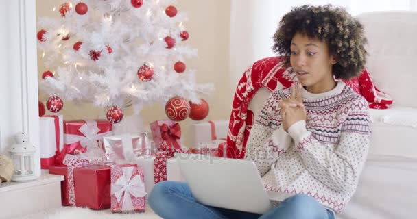 Молодая женщина печатает на ноутбуке на Рождество — стоковое видео