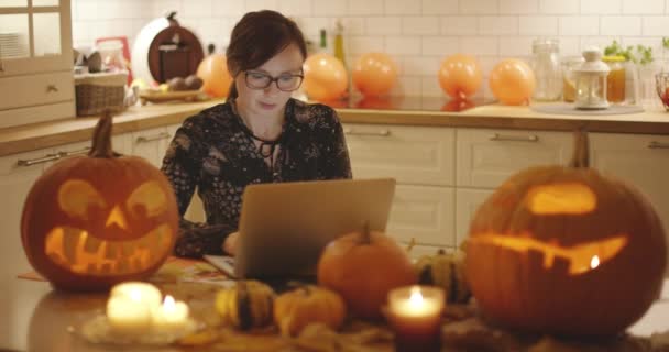 Женщина с ноутбука рядом Хэллоуин украшения — стоковое видео