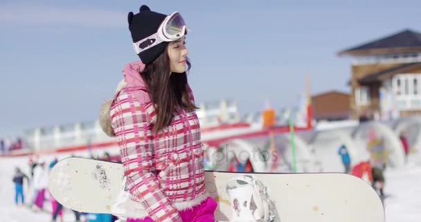 スノーボードと一緒に歩いている若い女性 — ストック動画