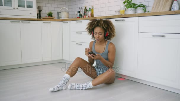 Laughing woman with gadgets in kitchen — Stock Video