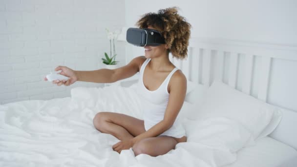 Smiling woman in VR glasses on bed — Stock Video