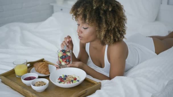 Soñando mujer teniendo dulce comida en la cama — Vídeo de stock
