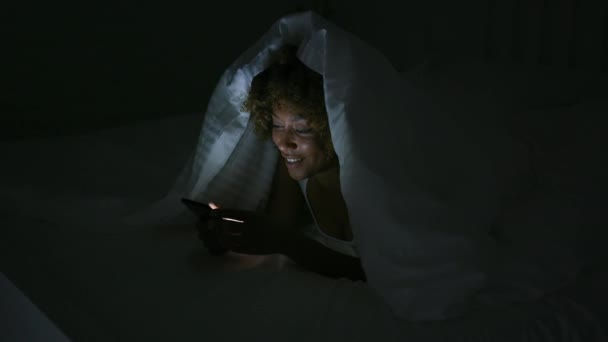 Mladá žena pomocí telefonu v temné místnosti — Stock video