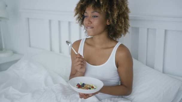 Young woman eating breakfast in bed — Stock Video