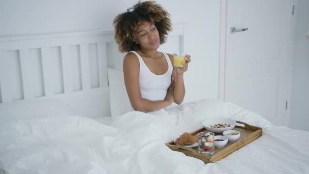 Conteúdo mulher desfrutando de café da manhã na cama — Vídeo de Stock