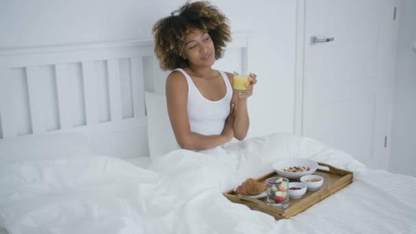 Contenu femme appréciant le petit déjeuner au lit — Video