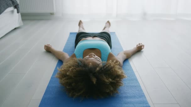 Жінка лежить на килимі розслабляється і дихає — стокове відео