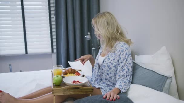 Femme gaie prenant le petit déjeuner au lit — Video