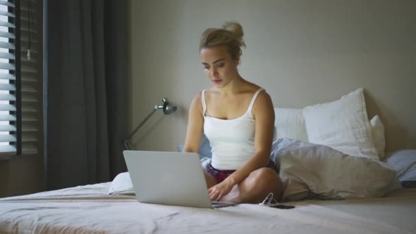 Donna affascinante che utilizza il computer portatile sul letto — Video Stock