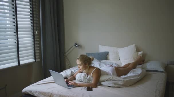 Очаровательная женщина в нижнем белье просматривает ноутбук — стоковое видео