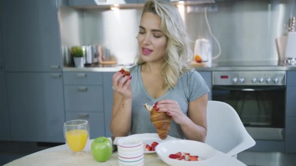 Frau isst Croissant zum Frühstück — Stockvideo