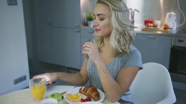 Uśmiecha się kobieta przeglądania smartfonem podczas śniadania — Wideo stockowe