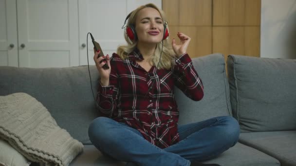 Vrouw die naar muziek luistert en zingt — Stockvideo